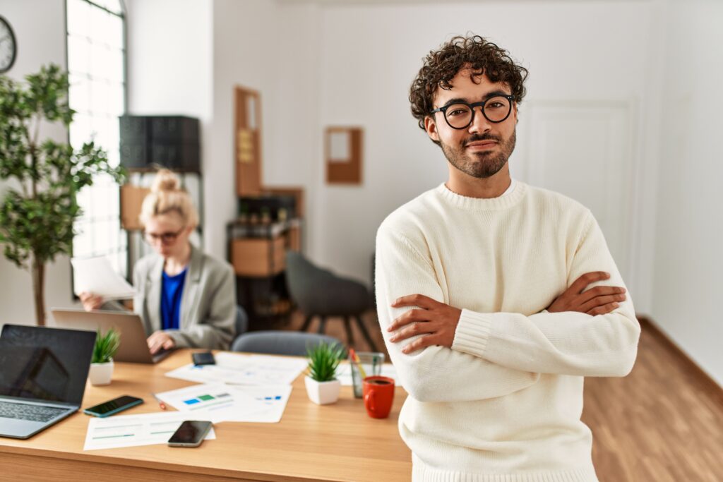 Businessman smiling happy with arms crossed gesture standing at the office.