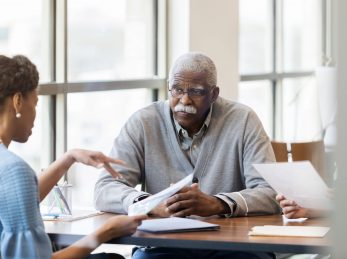 A senior African American man speaking with a loan officer