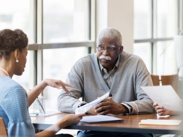 A senior African American man speaking with a loan officer